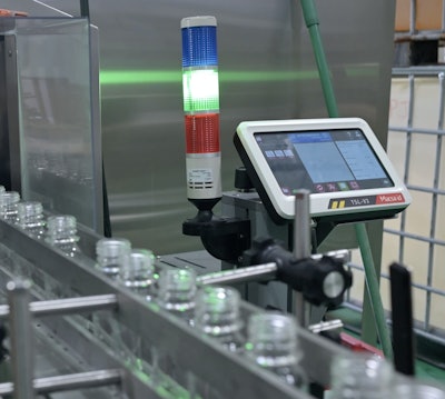 As bottles exit the unscrambler this laser coder puts date and lot code information on the bottom of each bottle.