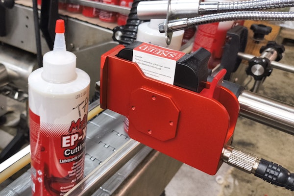 Lot and date code information is printed on the labeled container by this ink-jet printer.