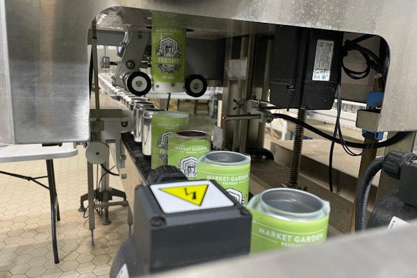 Shrink sleeves being 'shot' onto awaiting bright cans, pictured here traveling into the steam tunnel.