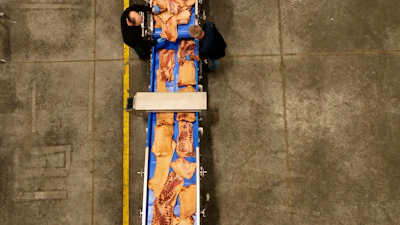 Slices of pork belly pass through a metal detector.