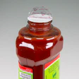 Red sauce bottle with white and green label against neutral background