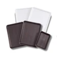Three dark and white rectangular baking sheets or serving trays stacked together
