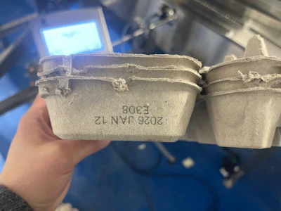 The side of each carton gets a clean, readable lot and date code.