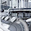 The oval-shaped linear track of the Beckhoff XTS is tilted by 45 degrees relative to the plane on which pucks deliver bottles to a capping station.