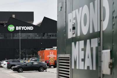 Beyond Meat facility with green and white corporate signage, parking lot, and orange delivery truck
