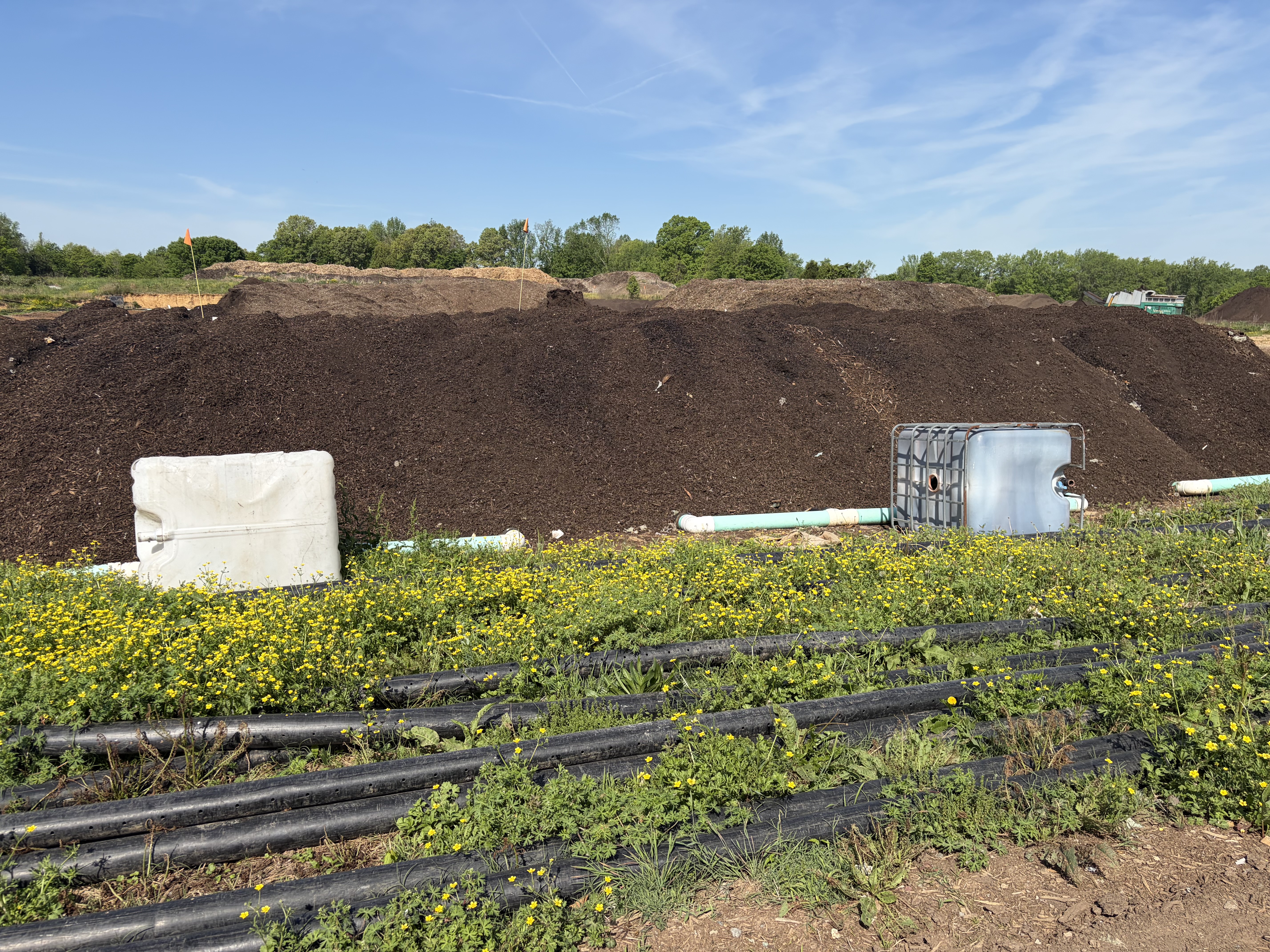 Aerated compost piles at The Compost Company are built over a network of pipes that push air through the material, helping generate and regulate the heat needed for decomposition. Sensors embedded in the piles transmit temperature data back to operators, allowing them to monitor conditions throughout the composting process.