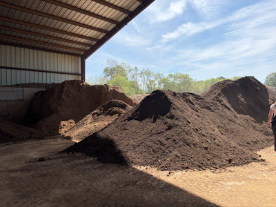 Finished compost at The Compost Company is stored and blended into soil products before being sold in bulk to farmers, contractors, and landscapers, completing the cycle from food waste to usable soil.