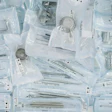 Sterilized dental and surgical instruments packaged in clear plastic pouches with printed labels and identification cards arranged overhead view.
