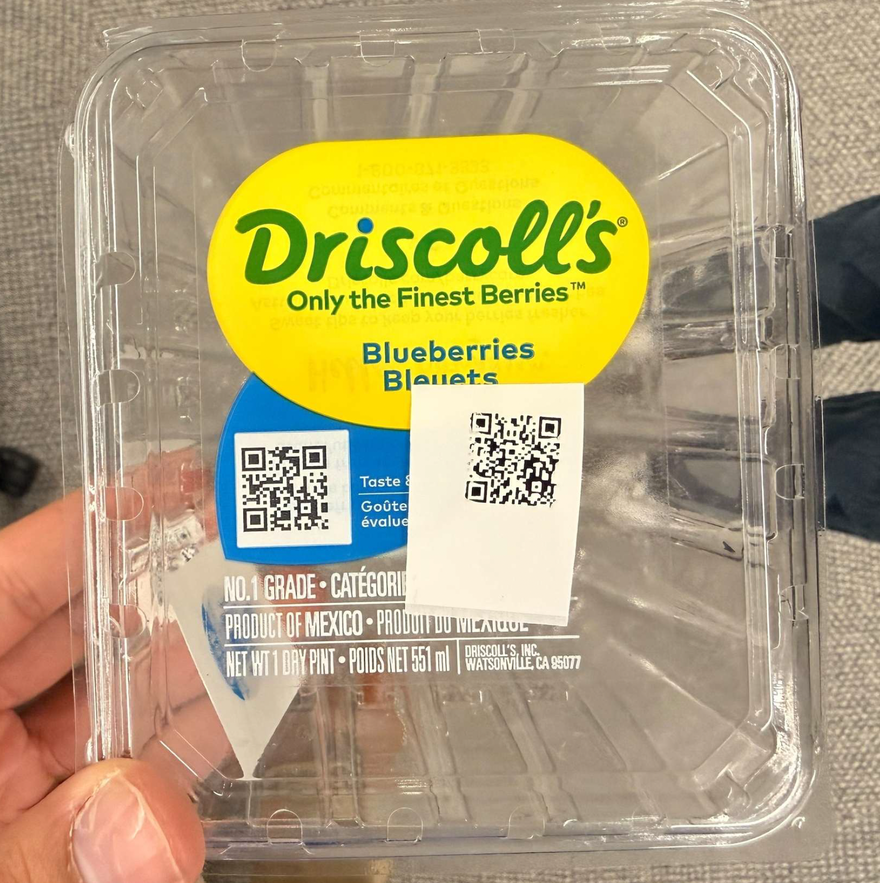 A Driscoll's blueberry clamshell carrying two QR codes &mdash; one pre-printed on the brand label, one applied at the farm. Together they're central to a serialization program that has given more than a billion packages a unique, traceable identity.