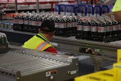 A line operator monitors product at a Coca-Cola Consolidated facility. MUST's real-time data has helped operators and maintenance teams identify equipment issues faster and with less wasted film.