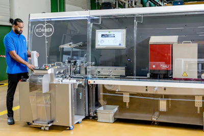 Technician in blue shirt operating industrial packaging or processing equipment in a manufacturing facility