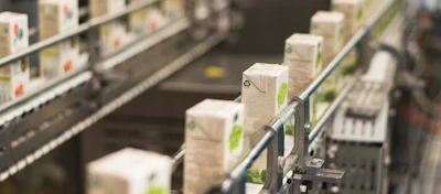 Cartons on conveyor belt in manufacturing or retail facility with selective focus