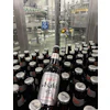 Both 12-oz (shown) and 21-oz bottles are filled on the line, and body labels in both cases promote the “Brewed in the USA” message.