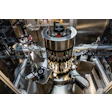 Industrial centrifuge or laboratory analytical instrument with metallic construction and multiple mechanical components in a research facility