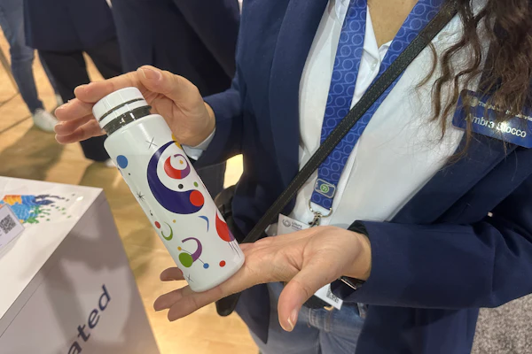 Ambra Stocco of Taghleef Industries holds a sample bottle with the company's shrink sleeve film at Loupe Americas.
