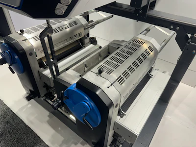 The finishing equipment behind on-demand metallization. Rather than laminating a full web of metalized foil, the process applies metal flake only where a printed binder calls for it.