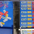 Colorful packaged products displayed on blue shelving units in retail warehouse setting