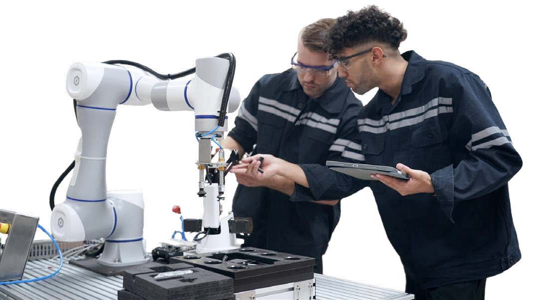 Two technicians examine a white and blue collaborative robotic arm while reviewing documentation on a tablet.
