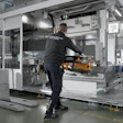 Factory worker operating industrial machinery in modern manufacturing facility