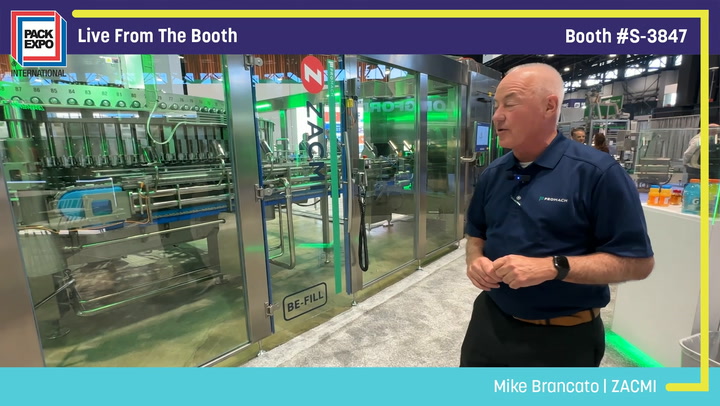 Man in navy polo shirt presenting industrial packaging equipment at PACK EXPO booth S-3847