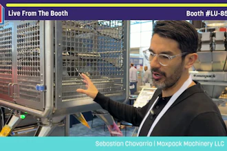 Man presenting industrial packaging machinery at Pack Expo booth LU-8547