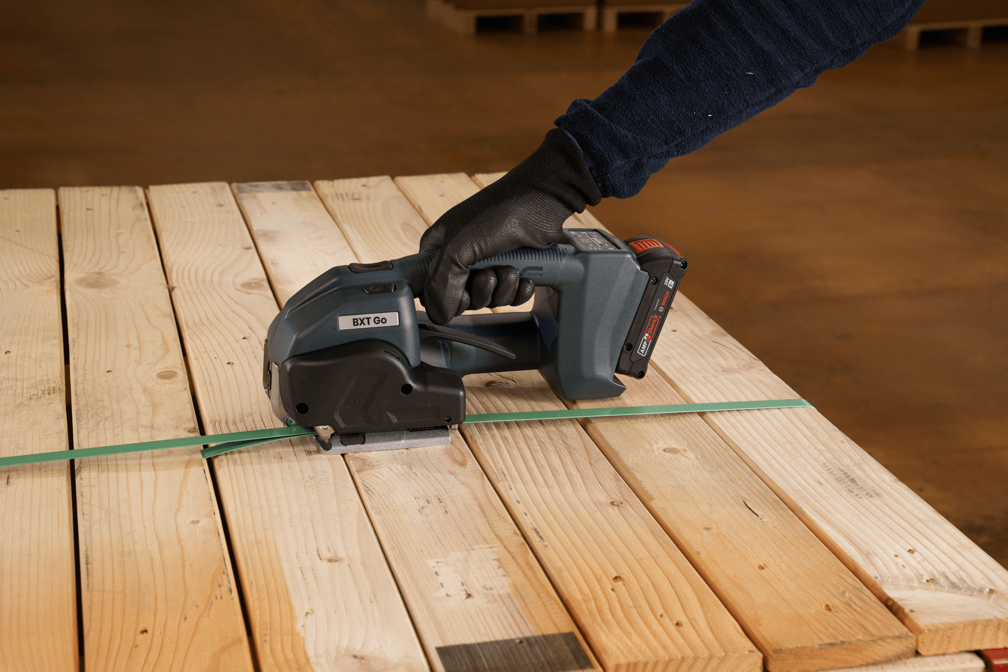 Worker using cordless power tool on wooden deck planks with green chalk line