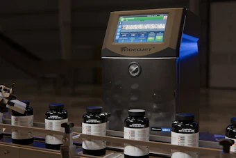 VideoJet industrial inkjet printer with multiple black ink bottles arranged on a production line