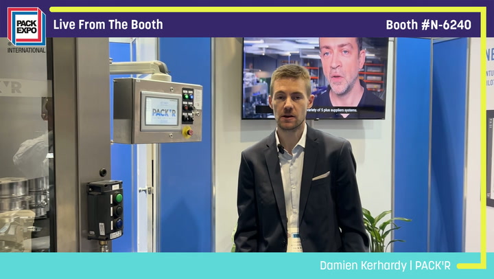 Professional man in business attire presenting at PACK'R booth during live trade show broadcast from Booth N-6240