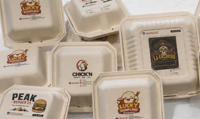 Collection of white takeout containers displaying restaurant logos including Lucky Dumpling, Chick'n, Peak Burger Co, and La Cacavera