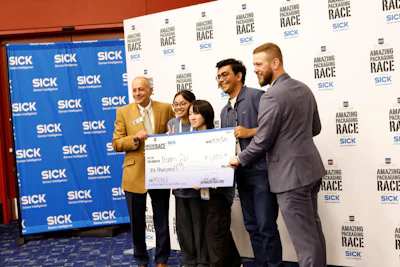 Team members and executives present oversized check at corporate awards event with SICK and Amazing Packaging Race branding