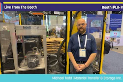 Man in blue shirt standing at Pack Expo booth LU-7841 with IntelliBreak material transfer equipment on display
