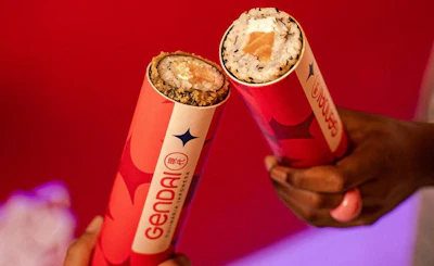 Two sushi burritos with Gendai branding held in hands against red background