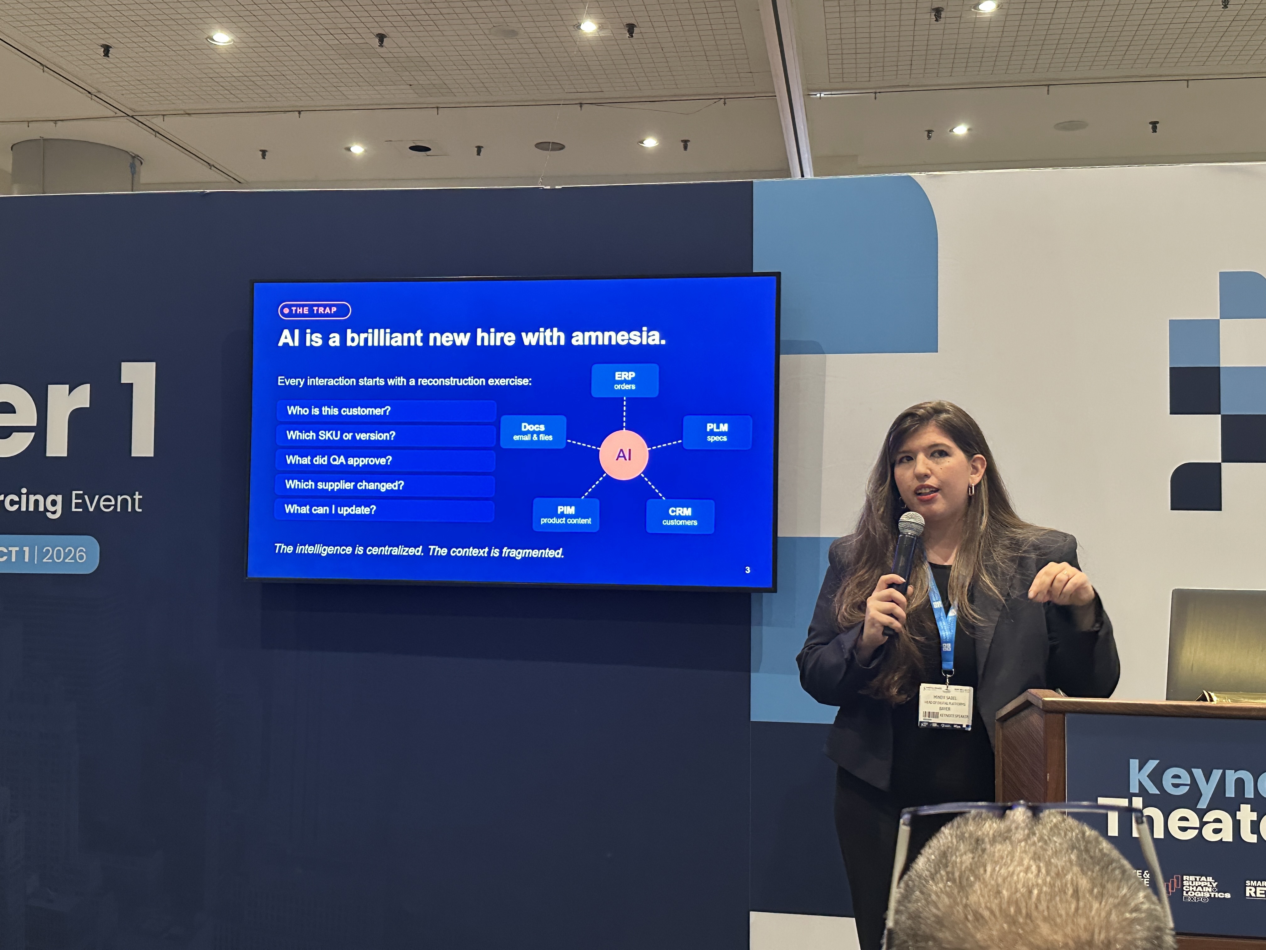 Professional woman presenting at conference with AI diagram on screen behind podium