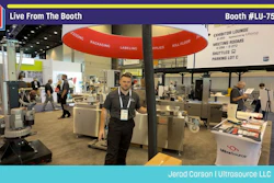 Professional at Pack Expo booth #LU-7503 demonstrating packaging equipment under red umbrella display