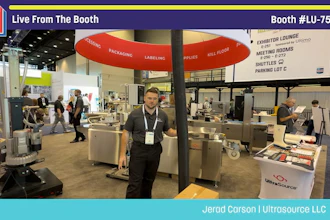 Professional at Pack Expo booth #LU-7503 demonstrating packaging equipment under red umbrella display