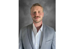 Professional headshot of a man in gray blazer and white shirt against neutral background