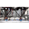 Large-format 3D printer with dual printing heads and metal frame structure in industrial workshop setting