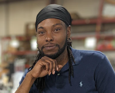 Man wearing navy polo shirt with headband in indoor facility