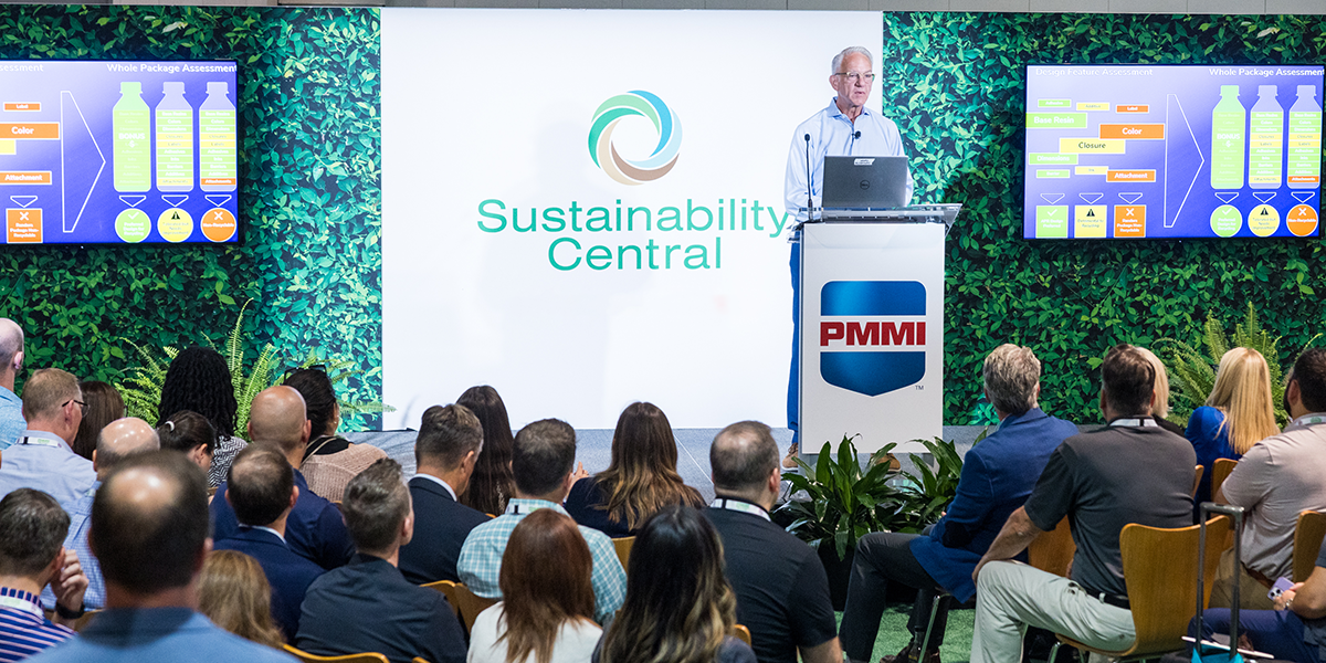 Professional presenting at Sustainability Central conference with PMMI podium and green plant backdrop