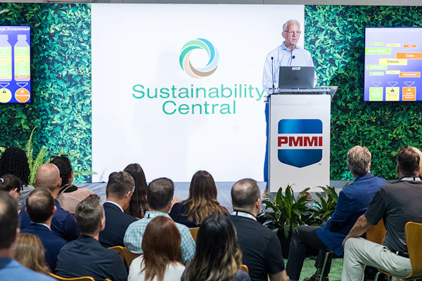 Professional presenting at Sustainability Central conference with PMMI podium and green plant backdrop