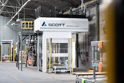 Scott Technology's Nexpal industrial hydraulic press machine in factory warehouse with yellow safety railings and equipment