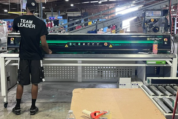 SMA employees finish each case on glue and tape equipment to prepare the bottom for picking. One person generally keeps up with case production, even at peak.