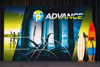 ADVANCE brand storefront display with surfboards and beach-themed imagery featuring pier architecture