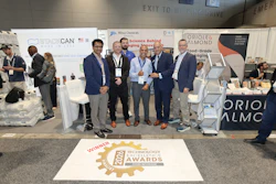 Group of business professionals posing at trade show booth with 2028 Technology Excellence Awards winner badge displayed