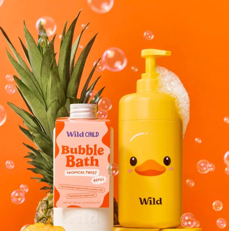 Wild Child tropical bubble bath and yellow duck-shaped soap dispenser with pineapple on orange background
