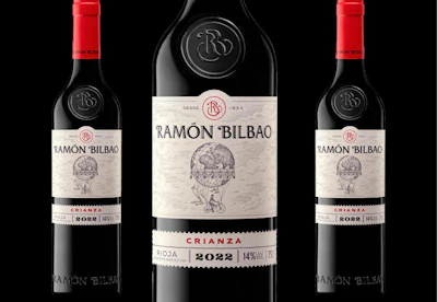 Three Ramón Bilbao Crianza 2022 red wine bottles with red caps and cream-colored labels against a black background